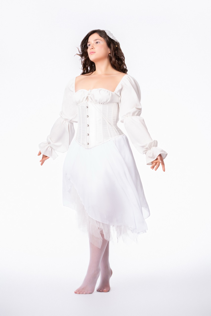 Model poses in an all white dress with flowers in her hair. Angelic. Mild Studios, Toronto, Ontario
