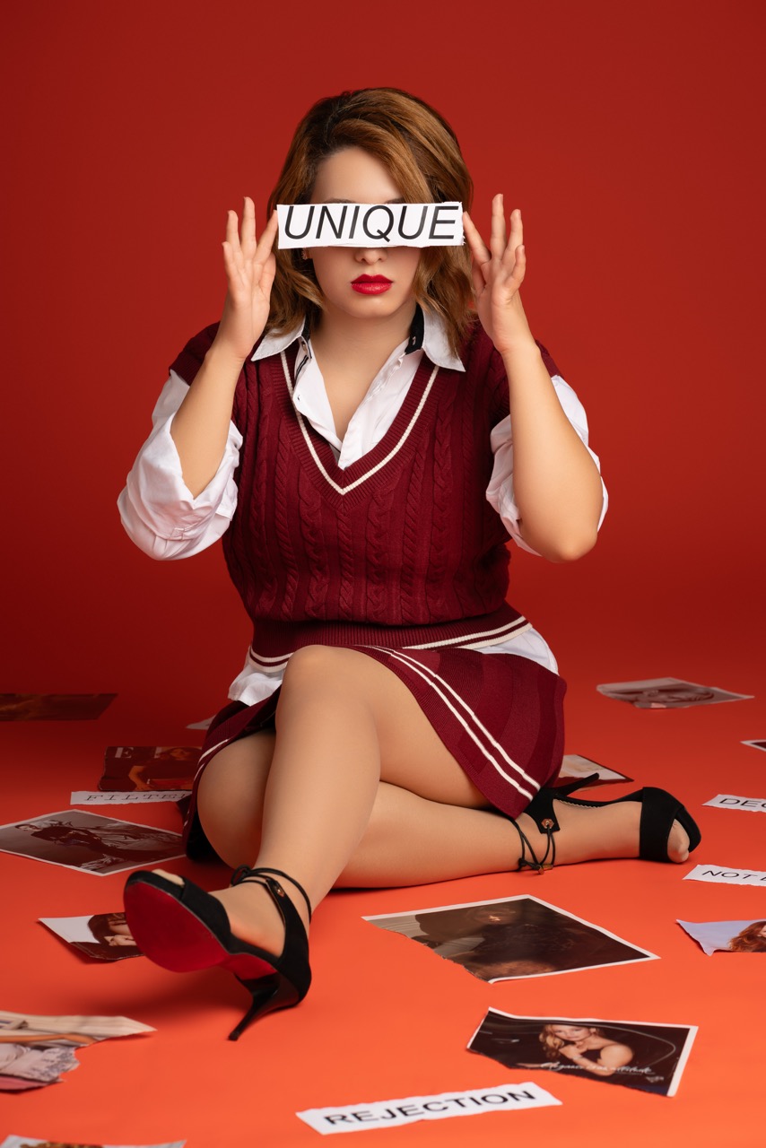 Model in a school uniform tearing up magazines, I Am Worthy series, at Mild Studios, Toronto, Ontario